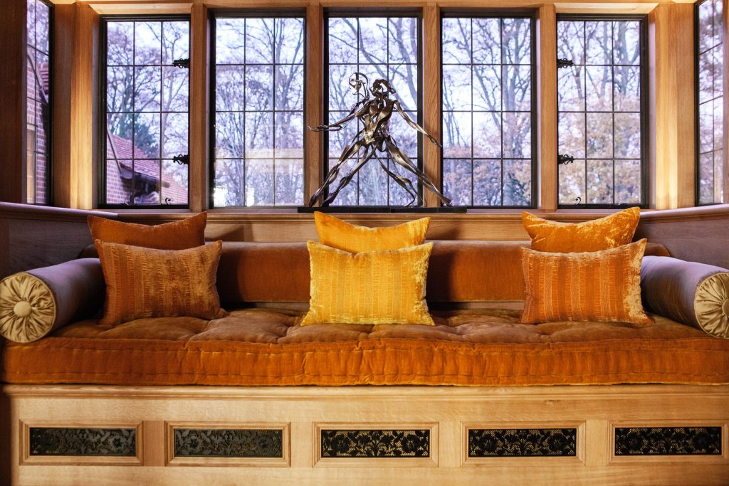 Oak bay window seat with black metal vent covers