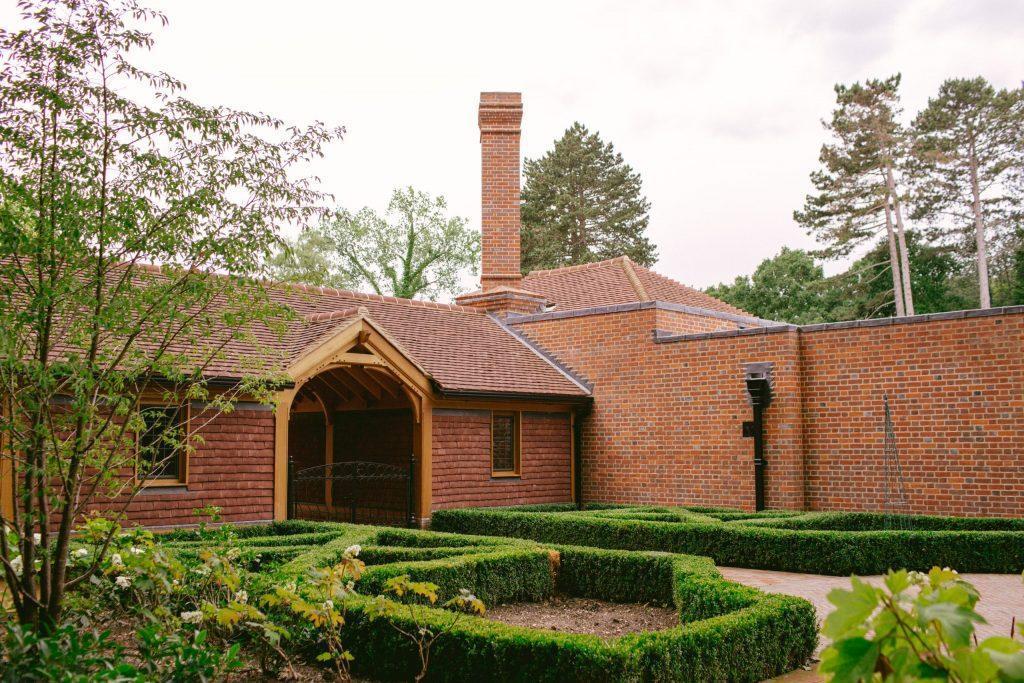 Brick Arts and Crafts courtyard and buildings Oak frame building with tile cladding