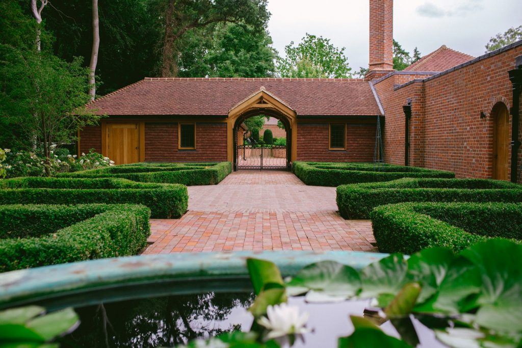 Formal arts and crafts courtyard garden with brick paths