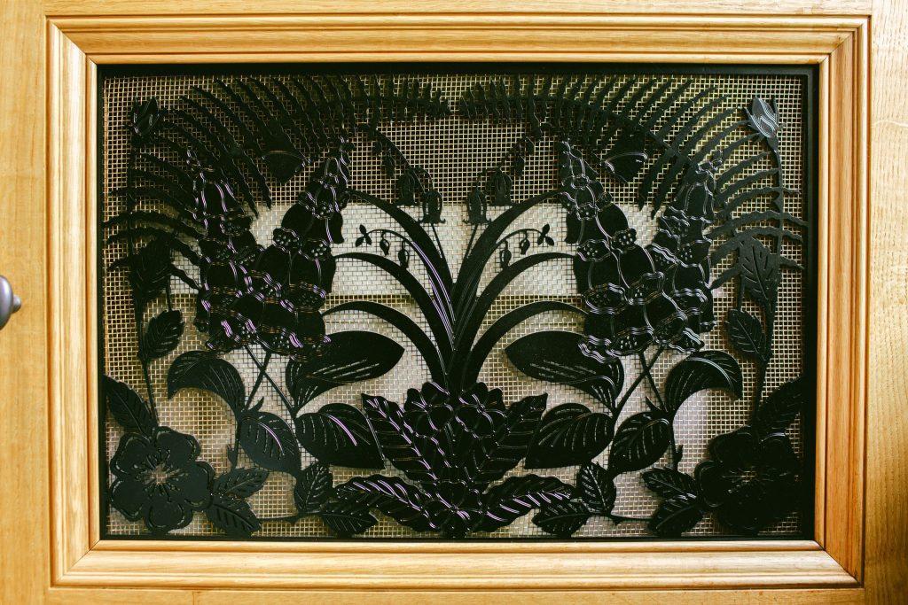 Decorative metal vent cover with foxgloves, bluebells and ferns