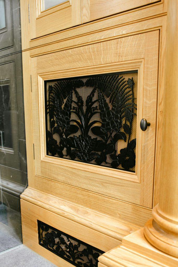 Decorative cut out metal panel in Oak Cabinet
