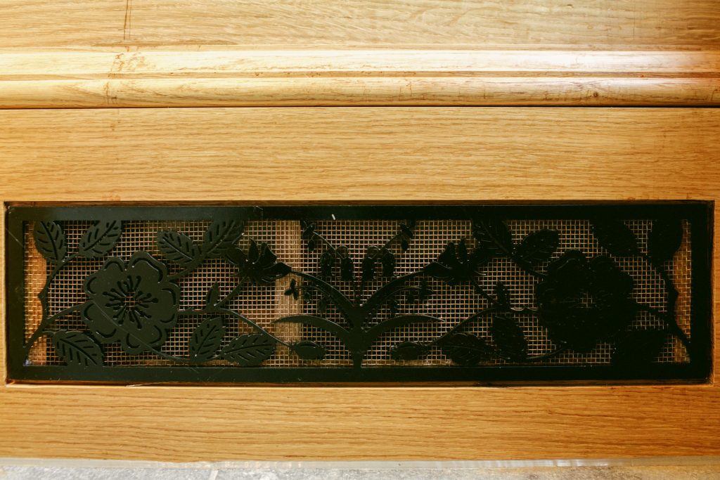 Slot vent with bronze mesh in Oak cabinet