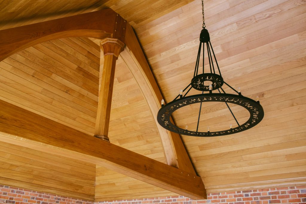 Ornate metal outdoor chandelier and Oak truss ceiling