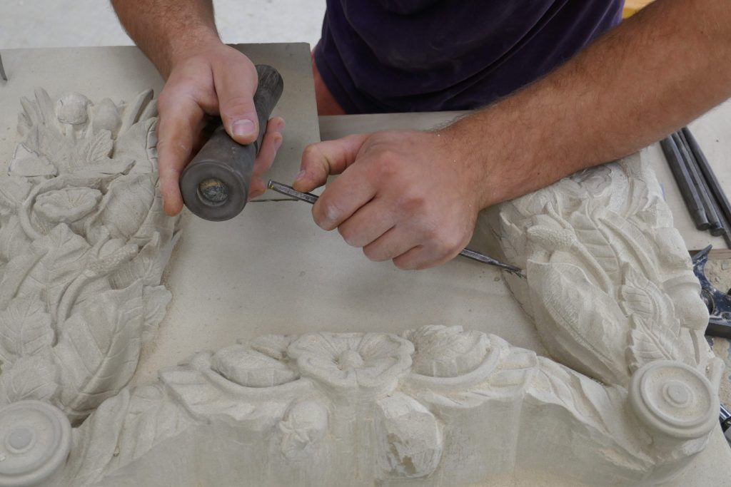 Stone mason carving intricate flowers