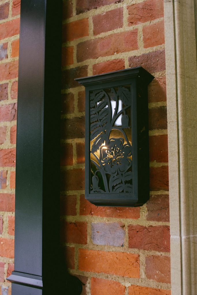 Metal garden wall light with cut metal pattern