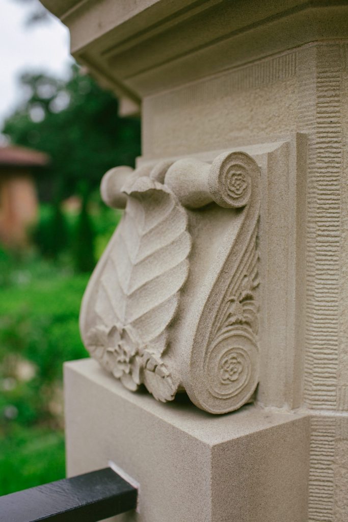 Carved stone scroll with beech leaf and dog roses