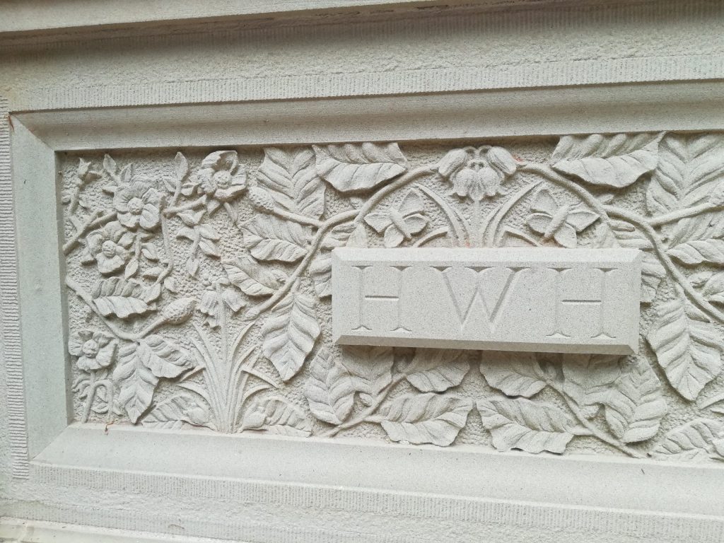 Stone carved plaque with leaves, flowers and butterflies