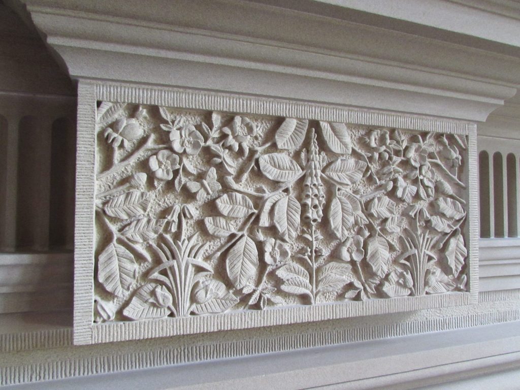 Carved stone fireplace keystone with foxgloves and beech leaves