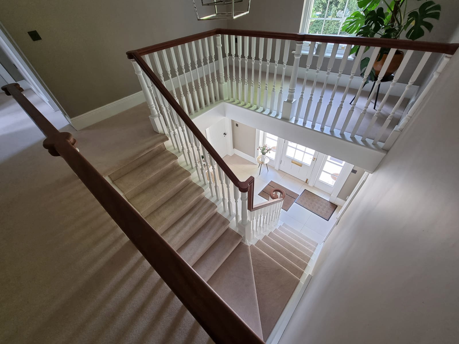 Traditional painted white staircase with wood handrail