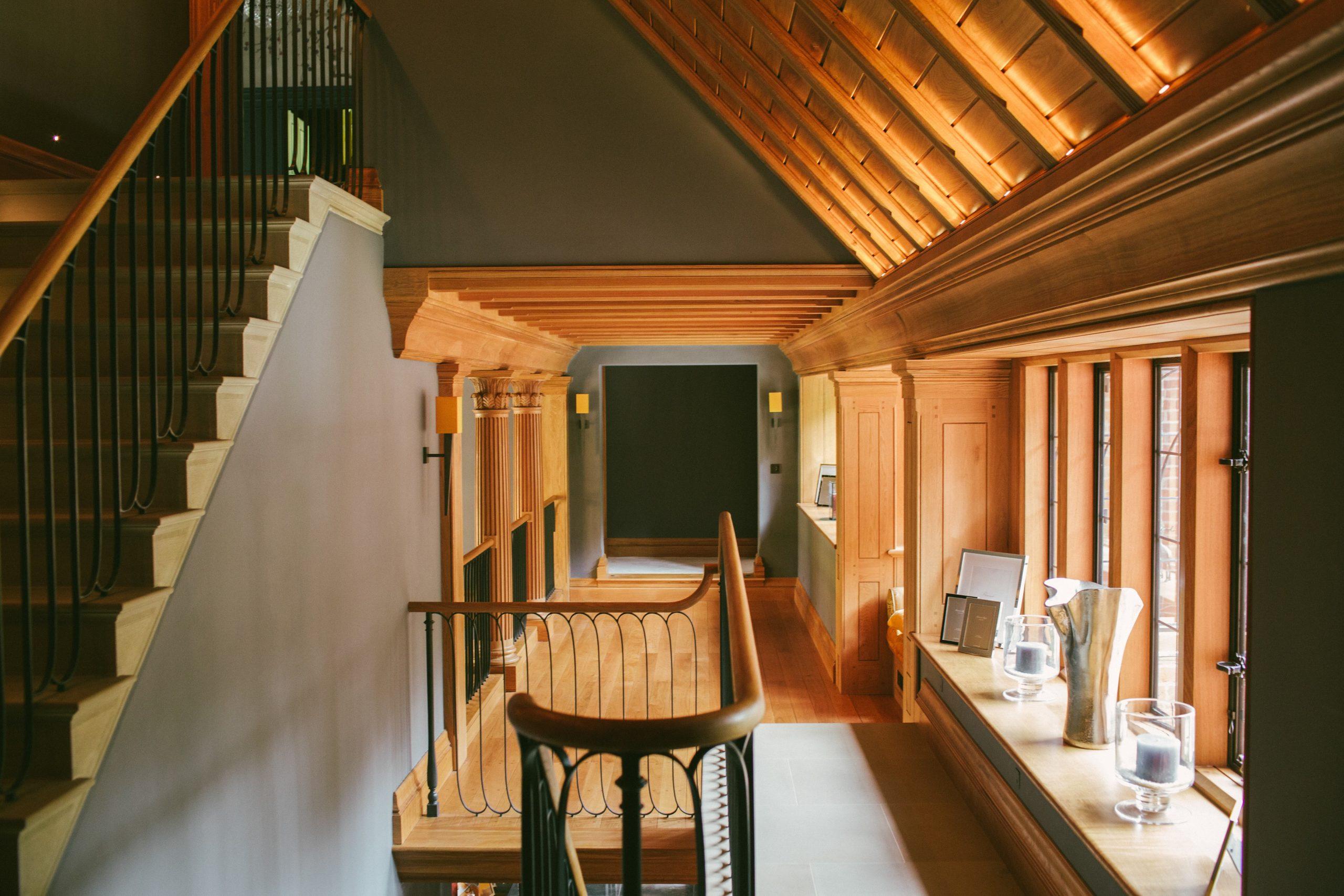 Carved stone staircase with metal handrail and Oak panelling