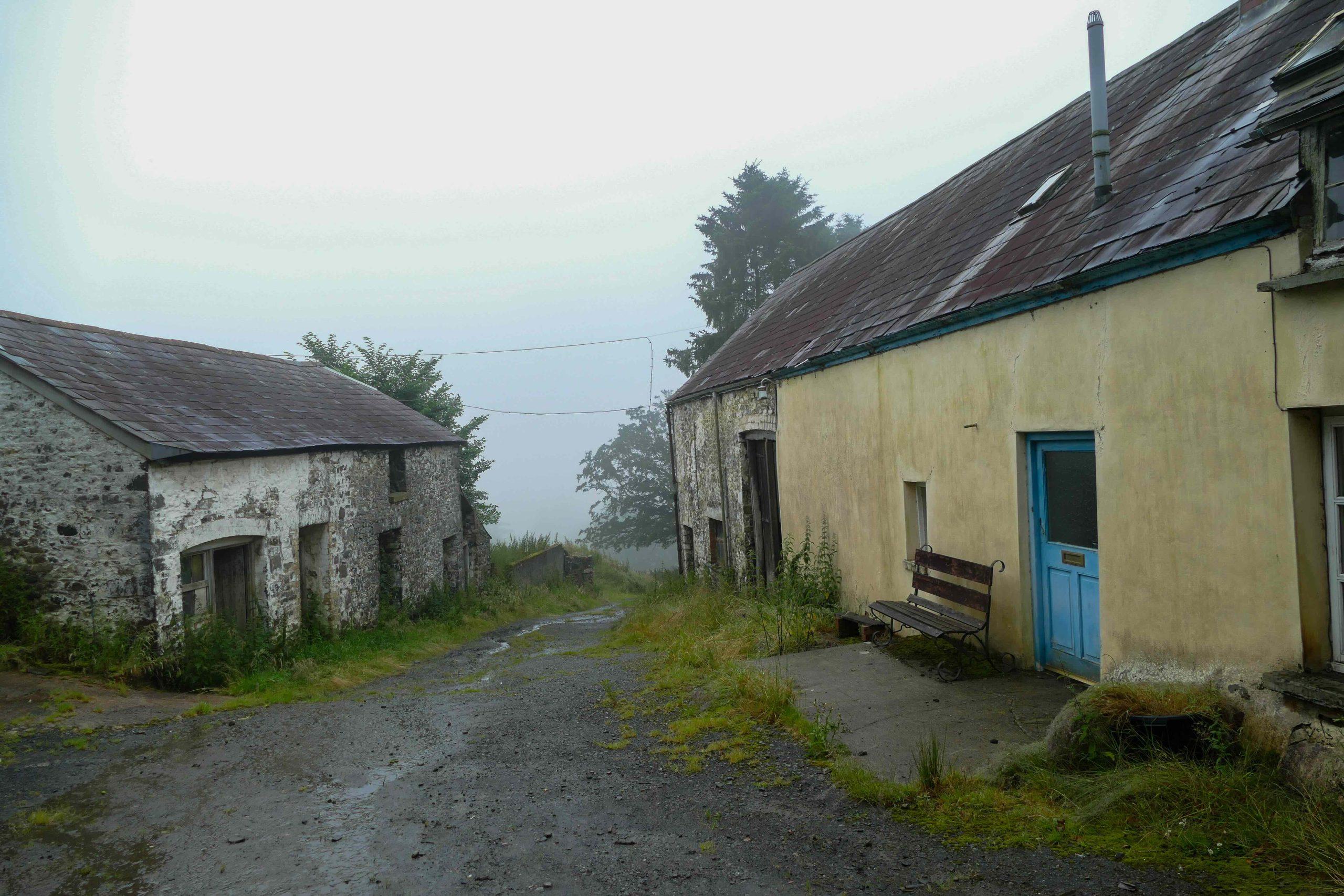 The Welsh farmhouse before restoration with modern render and failed roof.