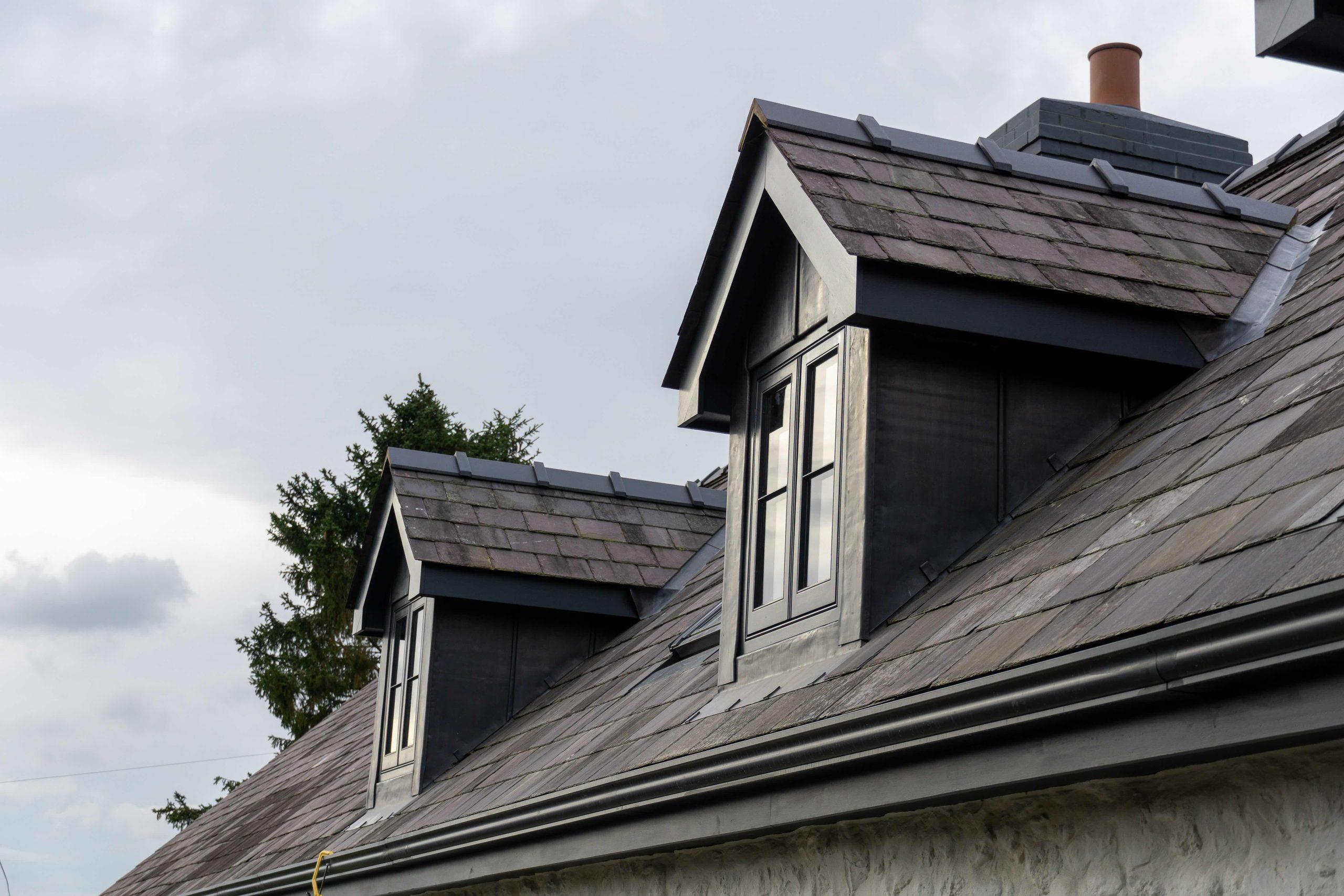 Traditional Welsh slate roof and dormer window dressed with lead cheeks, on longhouse restoration.