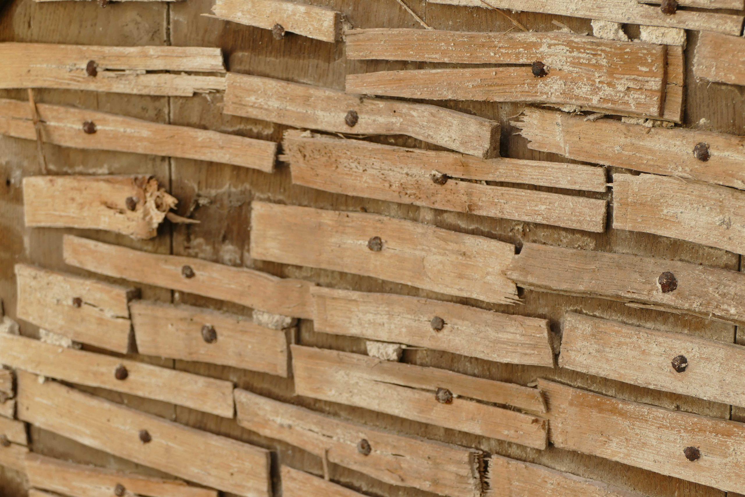 Exposed original wooden laths with the plaster removed for renovation.